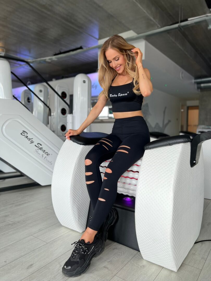 A woman sitting on the back of an exercise machine.